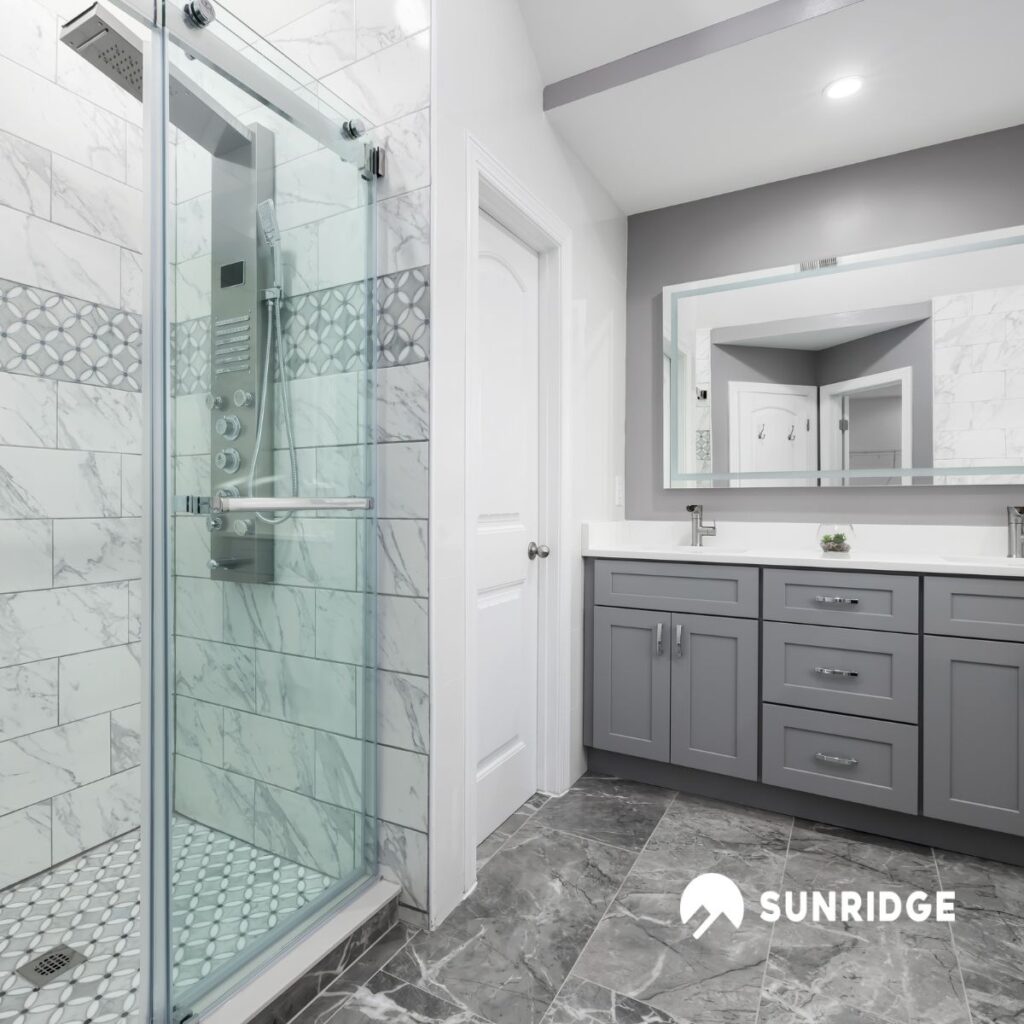 Modern bathroom with glass shower screen and wall mounted shower mixer taps, featuring elegant marble tile design.