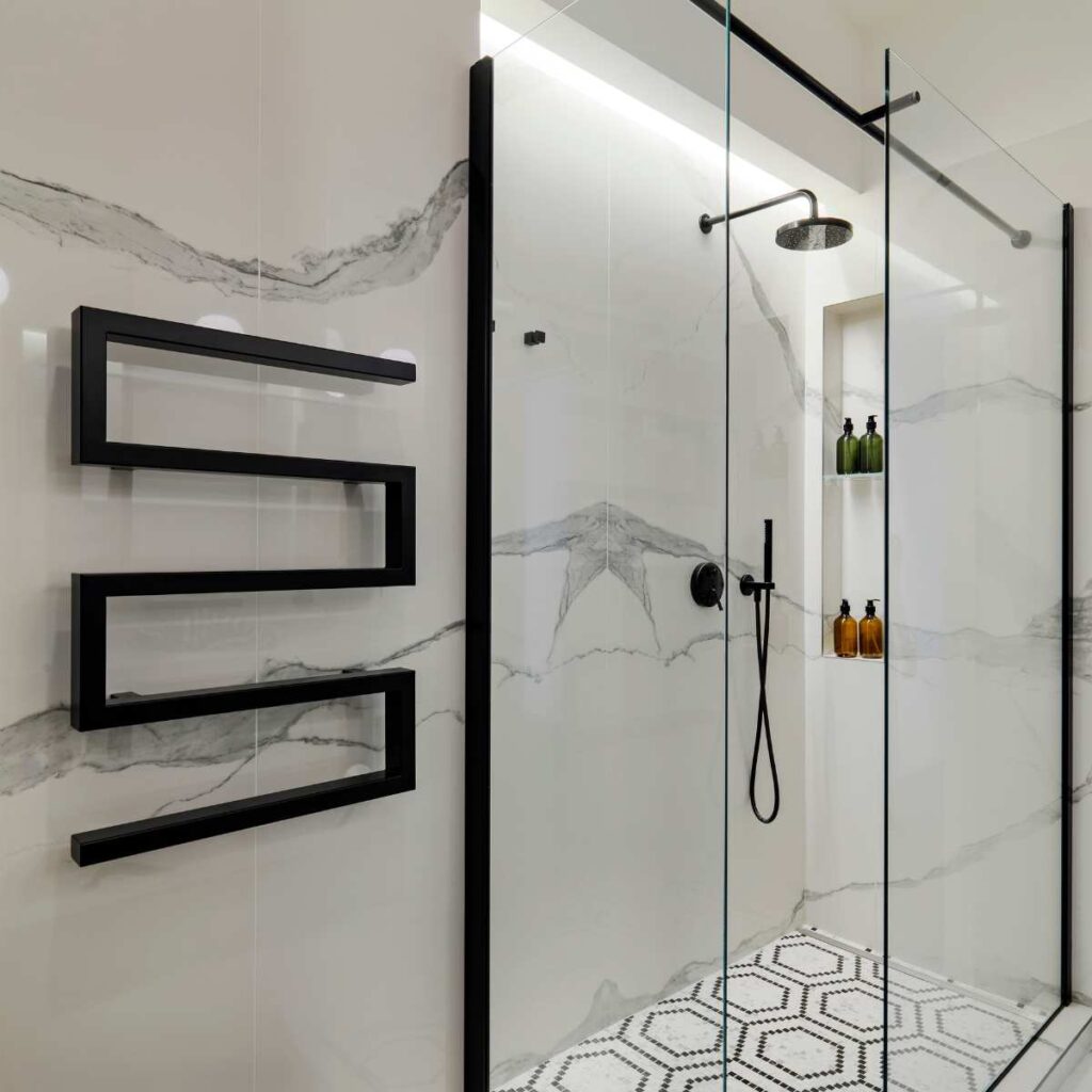 Modern bathroom interior featuring sleek black shower mixer taps and a glass shower enclosure.
