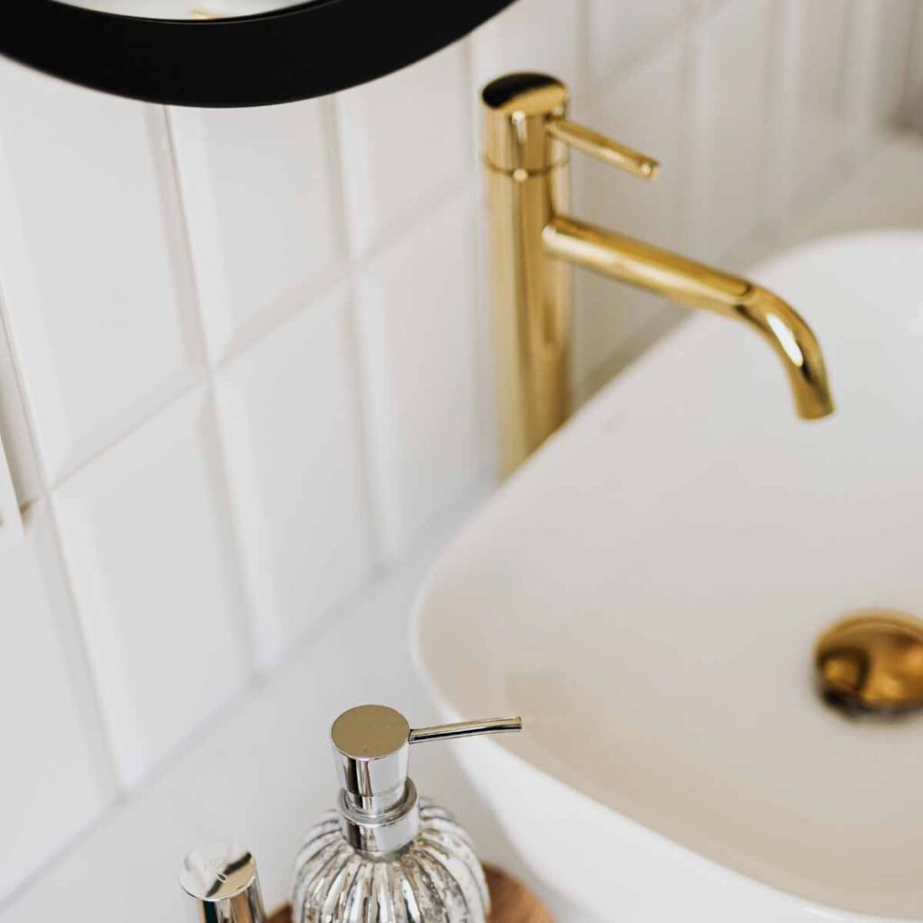 Modern gold bathroom mixer taps installed above a white basin, showcasing a sleek and timeless bathroom design