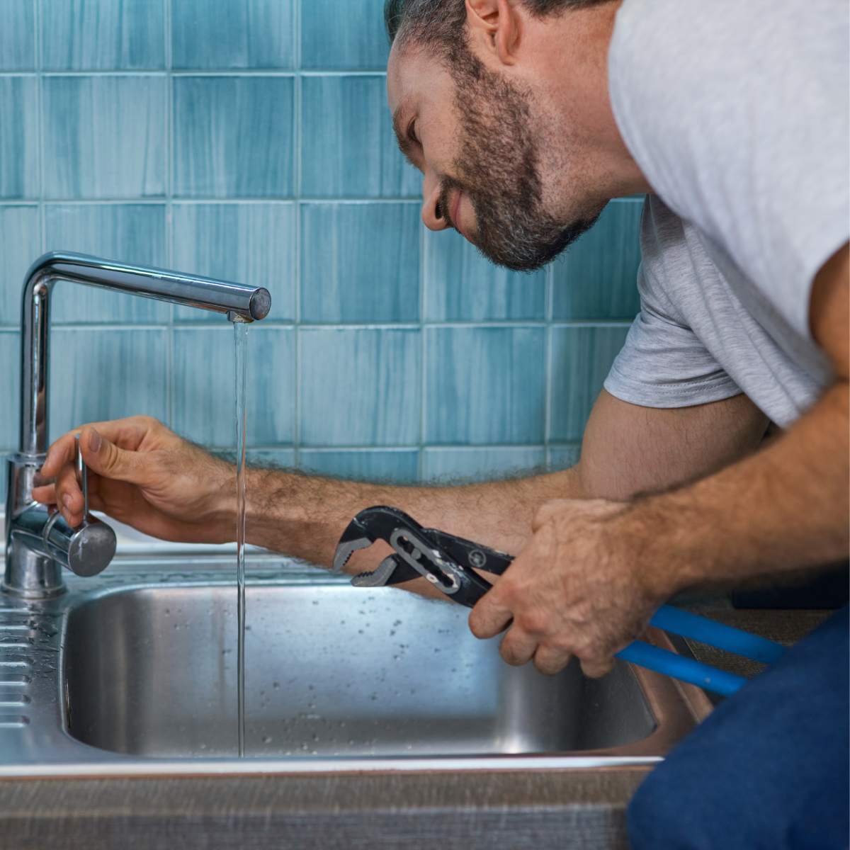 Plumber inspecting a mixer tap cartridge during a kitchen tap repair